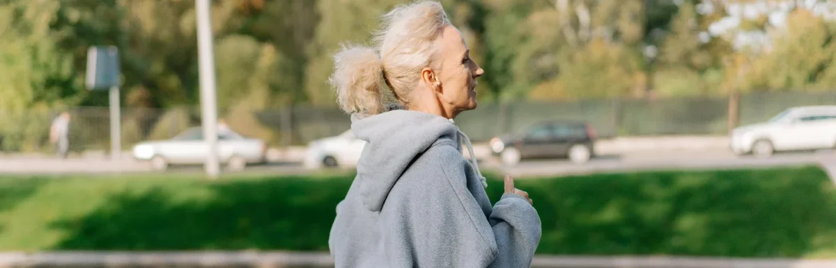 A woman walking briskly beside a canal in athletic wear